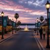 Custom printed avenue banners on light poles along a lakeside downtown street at dusk