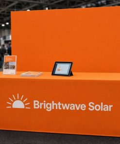 Orange fitted table cover with logo at a trade show booth