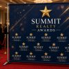 Step and repeat backdrop with textured navy background at an awards night